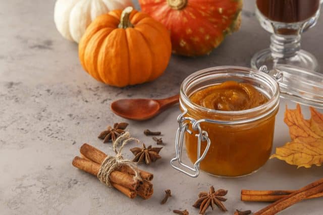 Pumpkin butter on concrete background, selective focus.