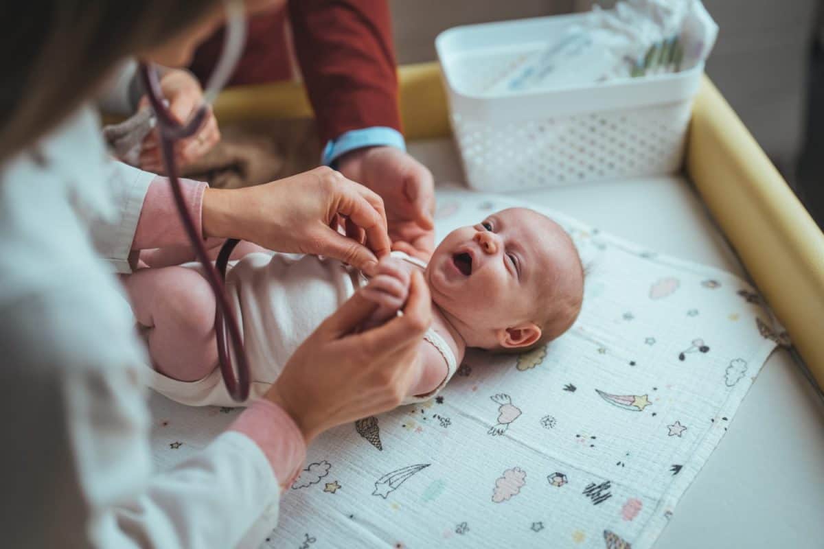 Soft blur of the doctor hands use stethoscope to check newborn baby health and take care him or cure the disease or disorder. Professional pediatrician examining infant.