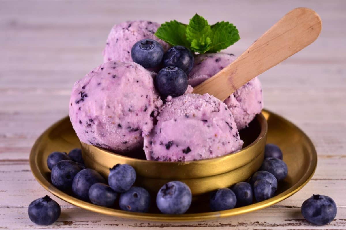 Blueberry ice cream in balls in a metal bowl. Close-up.