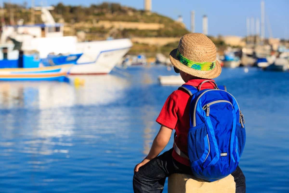 little boy looking at traditional boats in Malta, kids travel