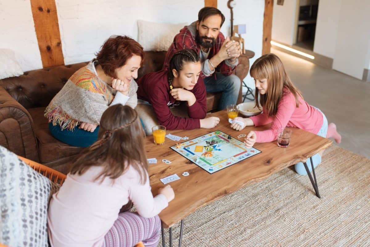 Happy family at home in the couch playing classic table games
