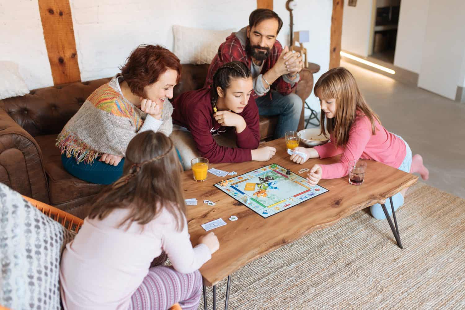 Happy family at home in the couch playing classic table games 