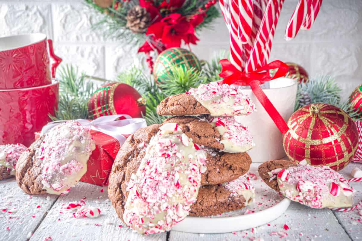 Homemade chocolate cracked brownie cookies dipped in white chocolate and candy cane bits. Idea recipe for Christmas party treats, winter holiday food