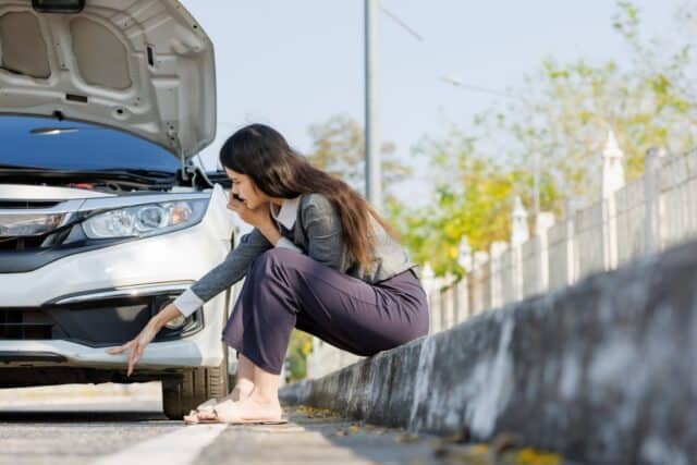 A young woman feels anxious as her car breaks down and stops by the roadside. She tries to call a relative for help