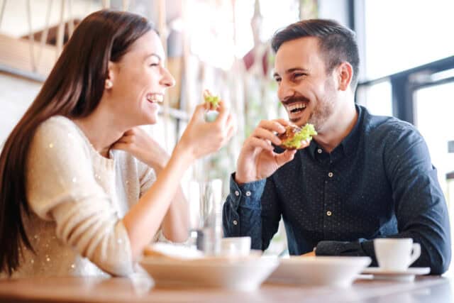 Happy loving couple enjoying breakfast in a cafe. Love, dating, food, lifestyle