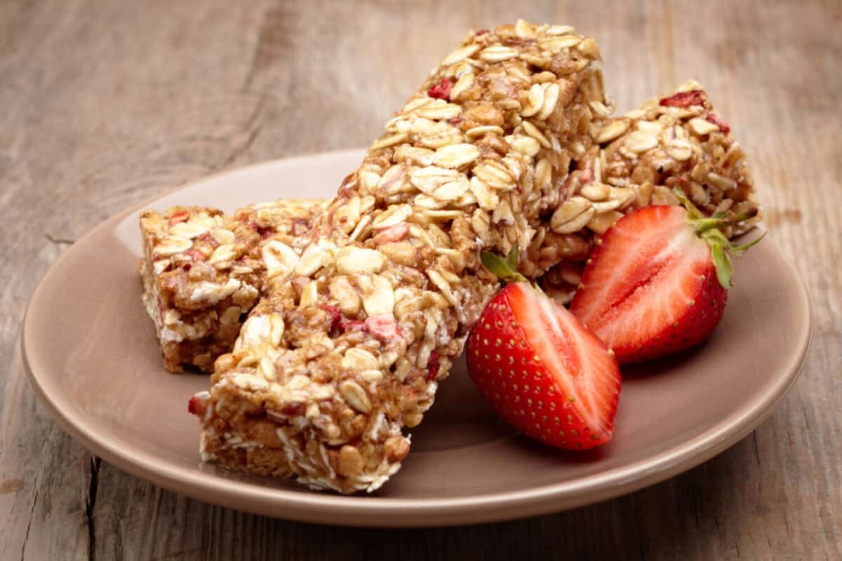 Granola bar with strawberries on plate