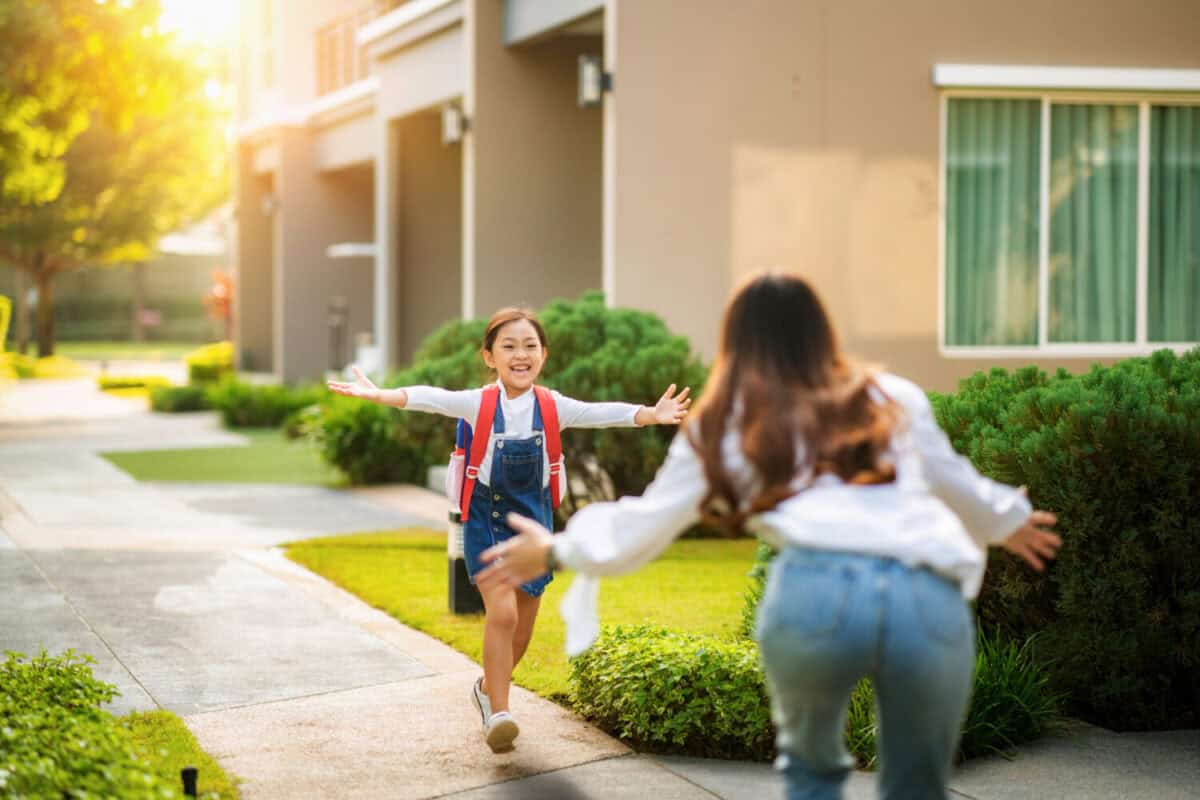 Asian daughter run to her mother after come back from her preschool, this image can use for single mom, school, family, education, home, house and outdoor concept