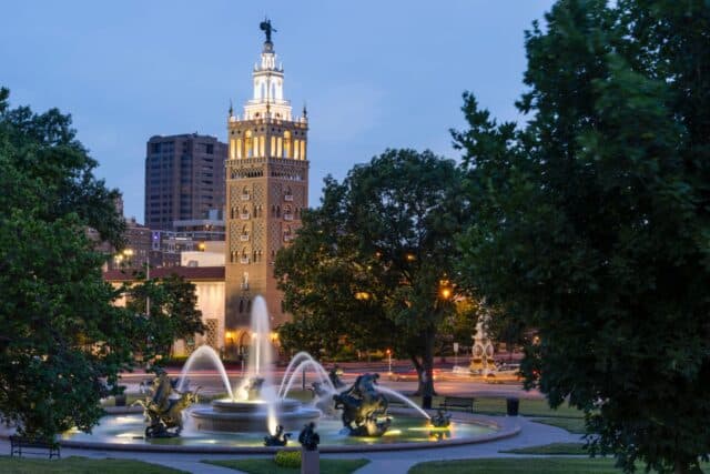 Twilight view of a historic fountain and skyline of Kansas City, Missouri, USA.