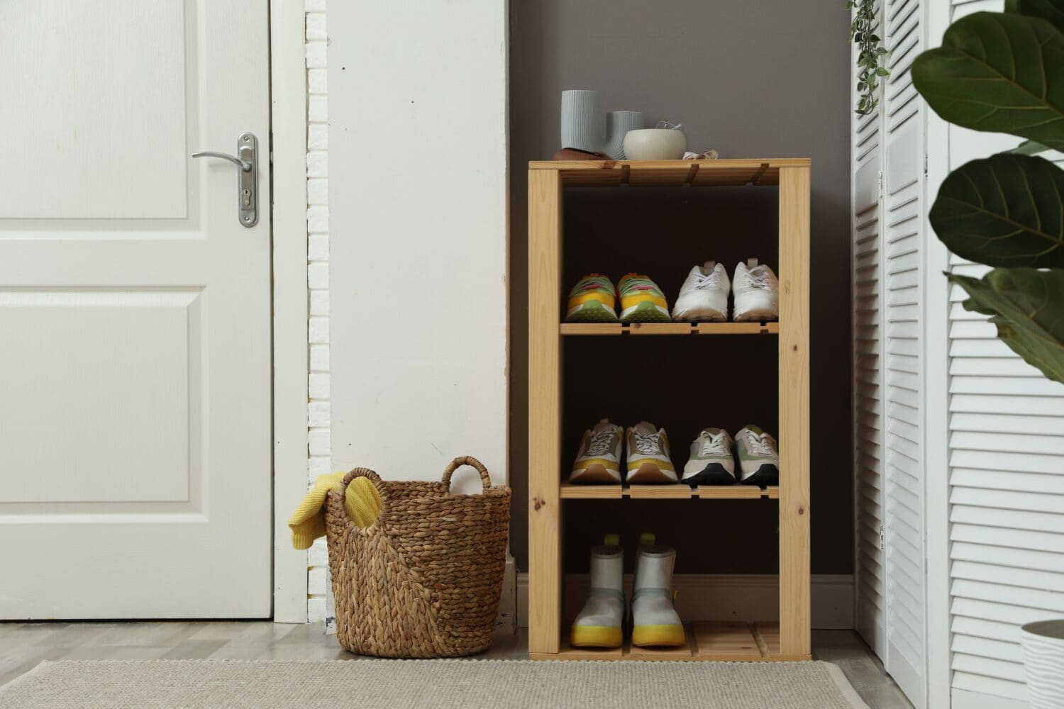 Different footwear on shelves in entryway. Shoe storage