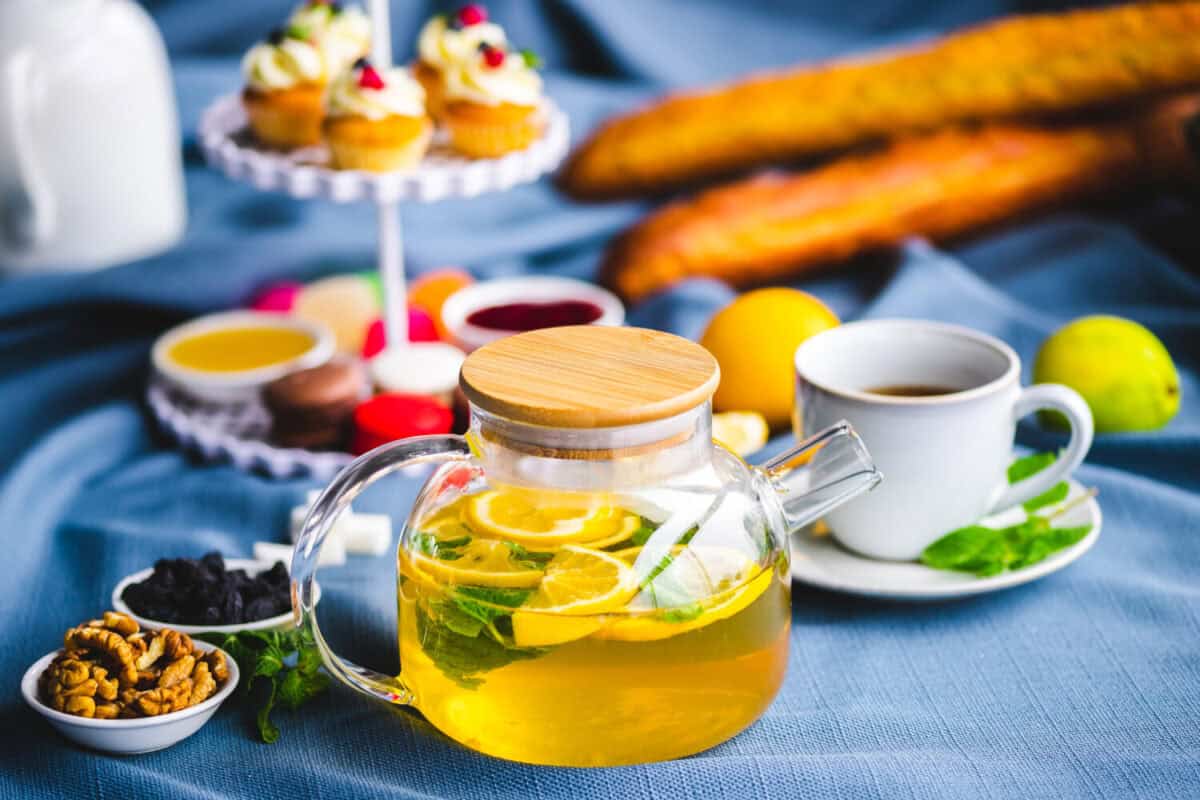 picnic. green tea in a teapot. tea in a cup. cupcakes on a plate