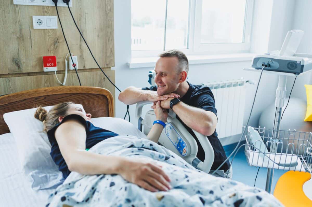 Husband and wife in the delivery room preparing for the birth of a child. The husband supports his wife during labor. The wife gives birth in the presence of her husband
