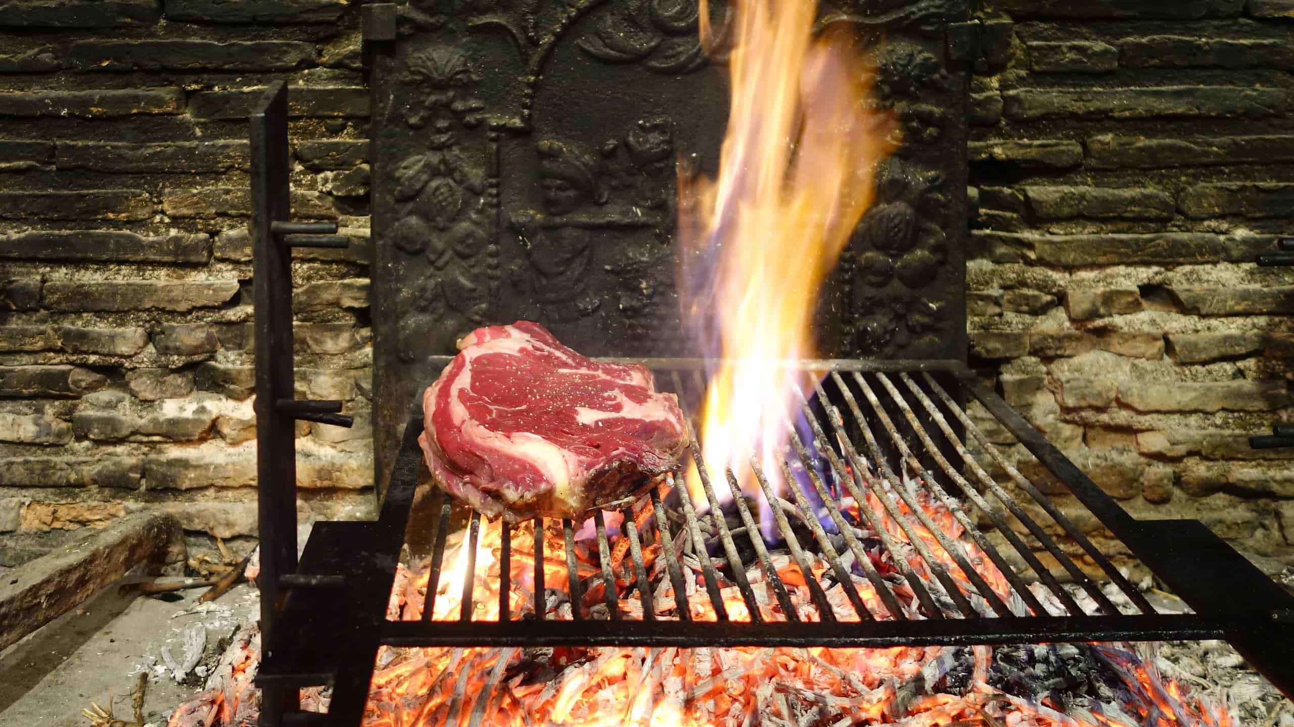 The rib steaks (cote de boeuf) being grilled on an open fire