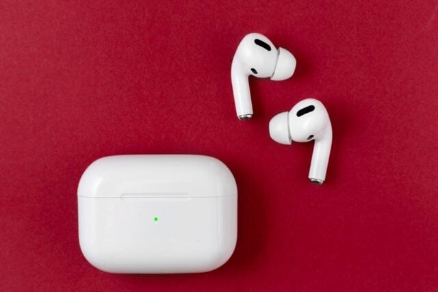 Air Pods Pro. with Wireless Charging Case. New Airpods pro on red background. Airpods Pro. Copy space