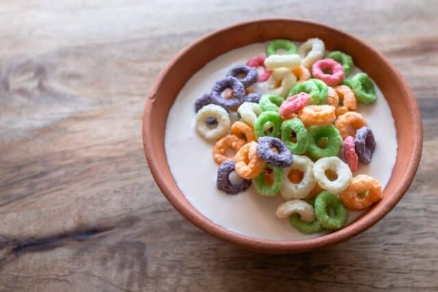 Multicolored grain or corn rings. Breakfast with yogurt. Clay bowl. Balanced nutrition. Healthy Lifestyle. Colorful food. Nutritious snack.