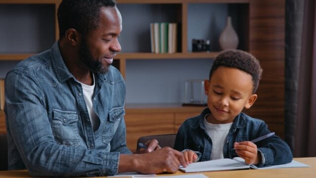 African American family clever father help son writing letters write homework man teacher tutor teaching little ethnic boy kid child pupil preparing to school dad distant busy elementary education