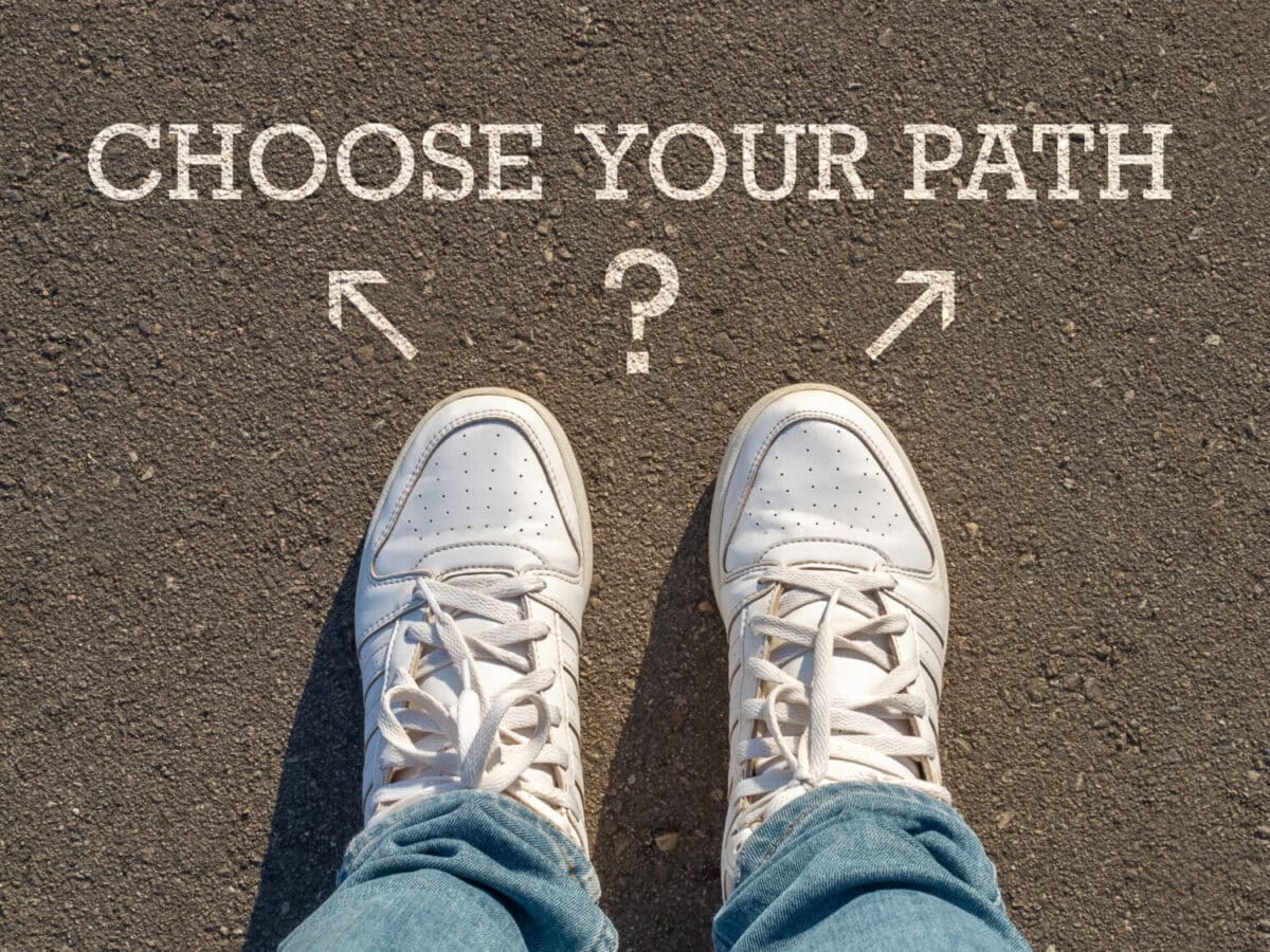 photo on top of the sneakers and the inscription choose your path on the asphalt, the concept of free choice, direction of movement, the philosophical question of life