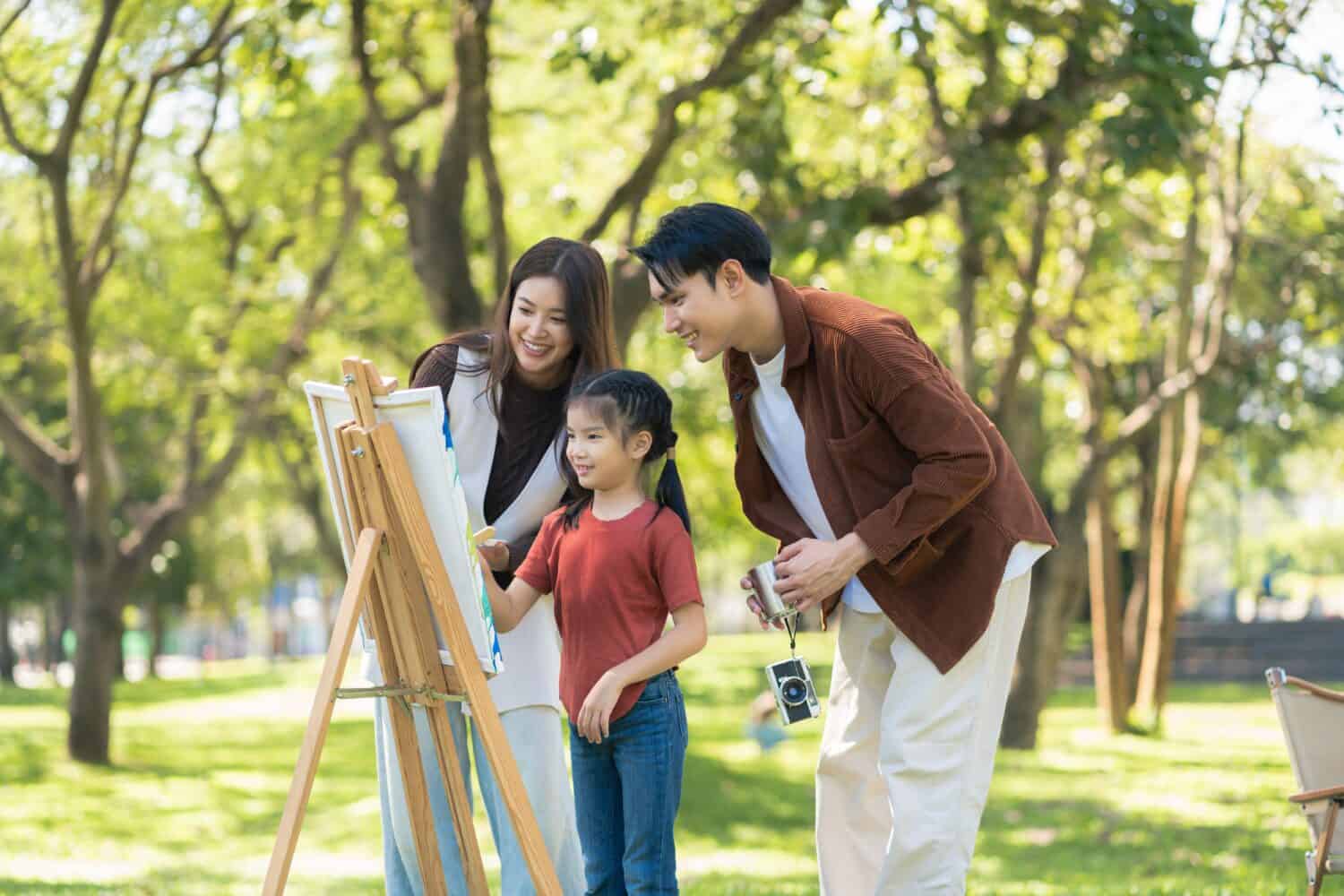 Happy asian family picnic in park, weekend lifestyle outdoors.