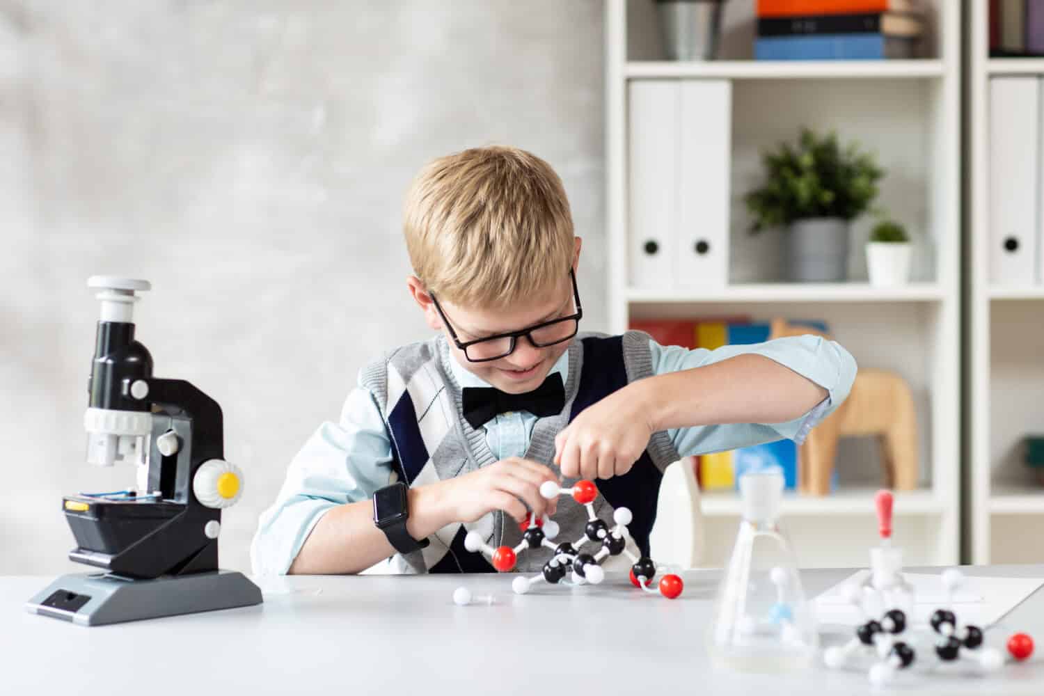 Cute child in casual clothes assemble a model of a chemical element