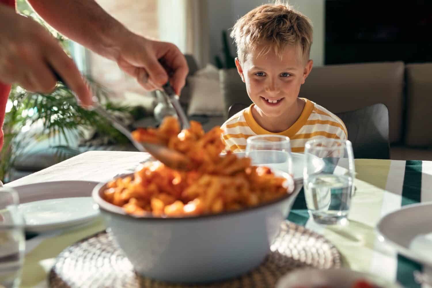 Shot of beautiful kind family talking while eating together in the kitchen at home