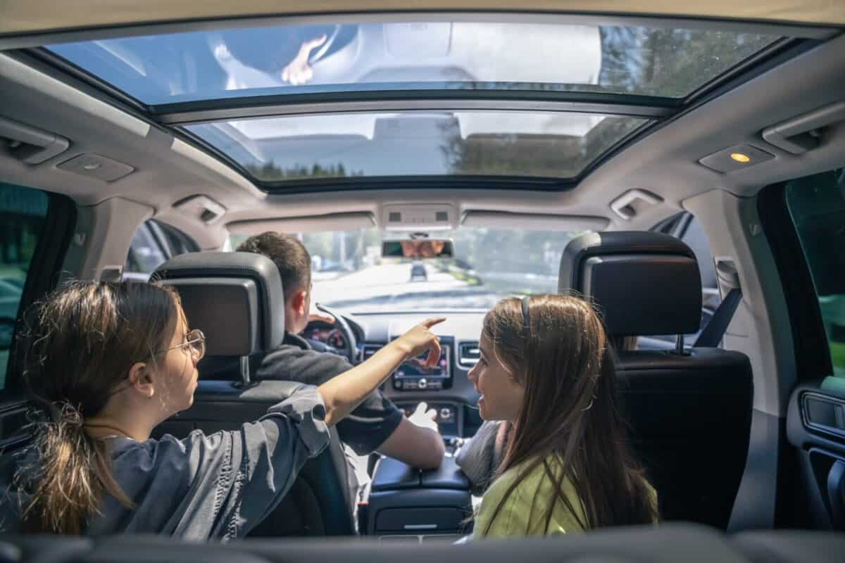 Little girls sitting in back seat of car during family trip.