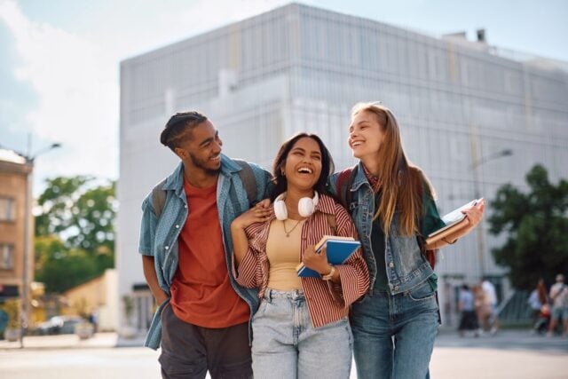 Group of happy university students goin on a lecture together.