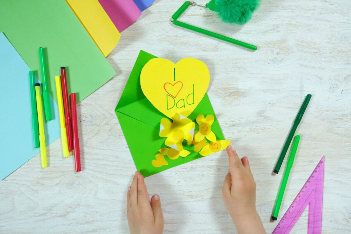 Greeting card for on Father's Day heart with lettering. Envelope crafts and flower from colorful paper. Handmade. Children's creativity project, crafts for kids. DIY concept.