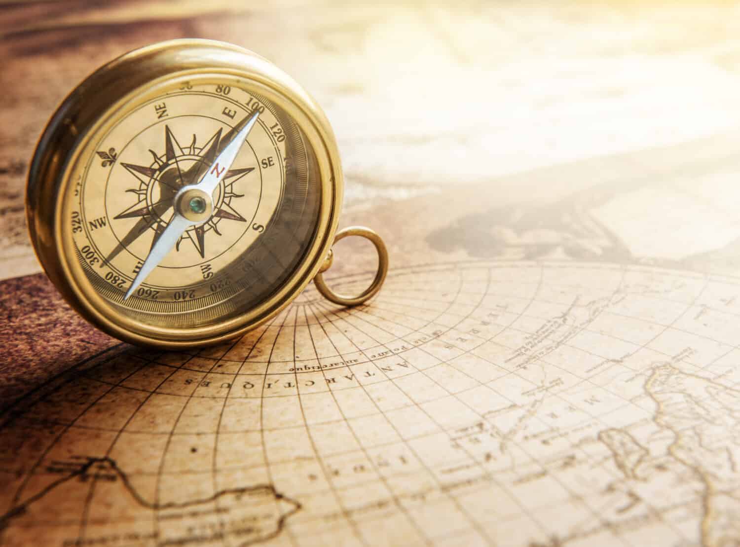 Old compass on vintage map. Retro stale.