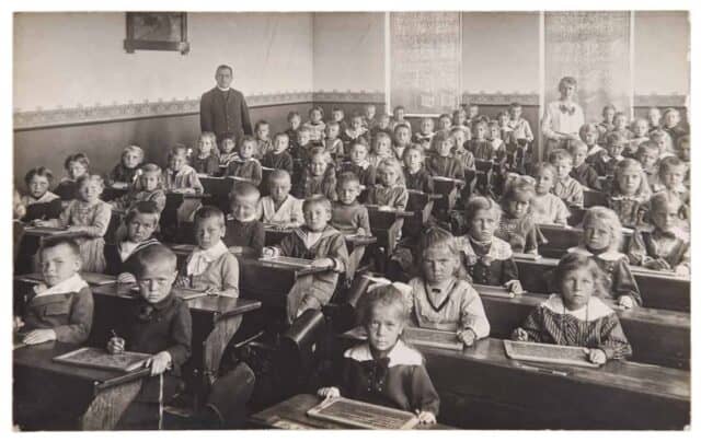 Antique portrait of school classmates. Group of children and teachers. Vintage picture with original film grain and blur
