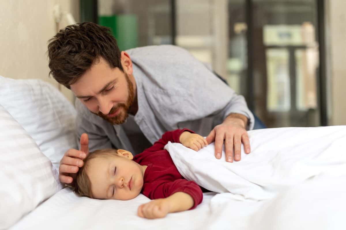 Father looking at his sleeping baby tenderly.