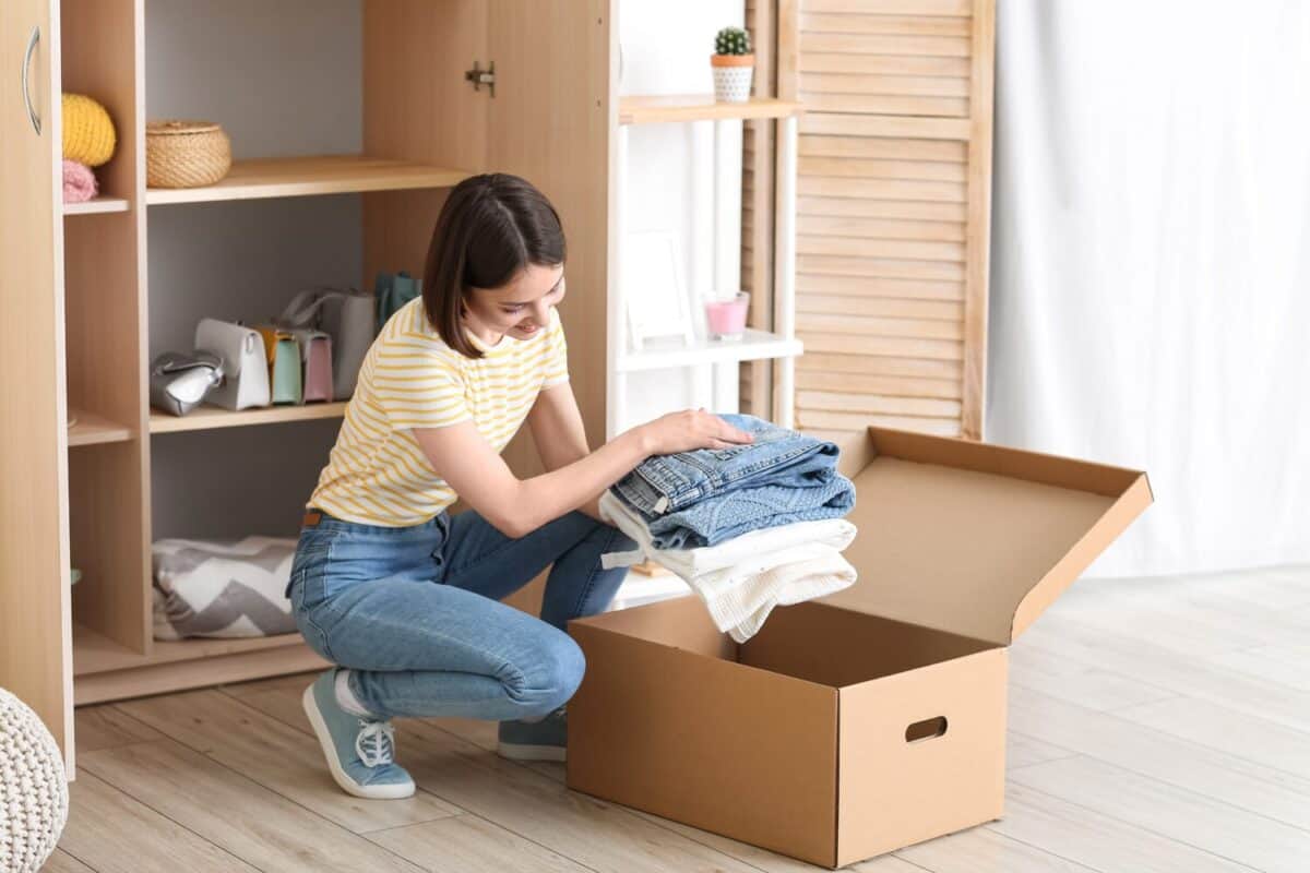 Young woman arranging clothes at wardrobe