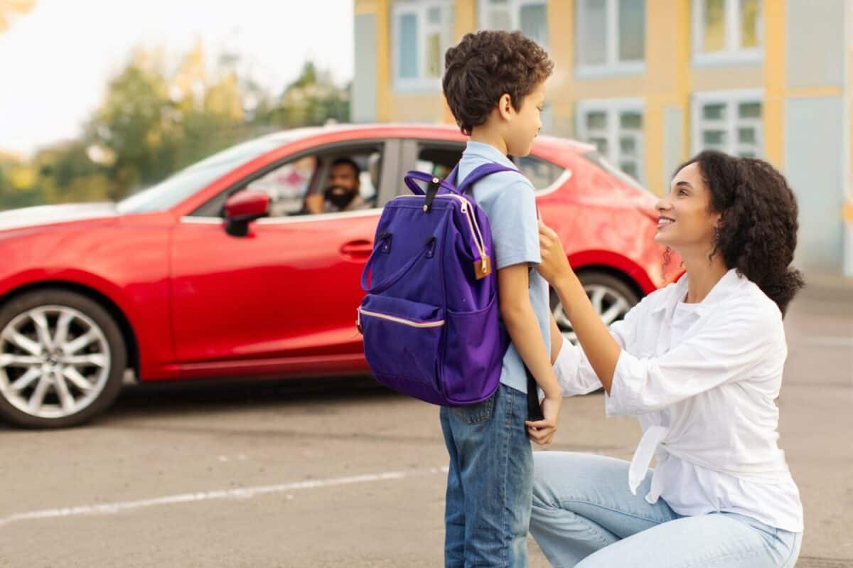 Young Latin mother talking to her son in front of car on parking before send child boy to school, education, back to school concept
