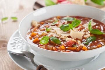 Minestrone soup with cheese and basil, selective focus