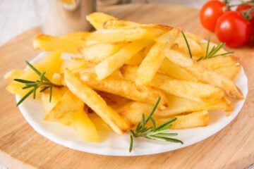 homemade french fries with rosemary on white plate