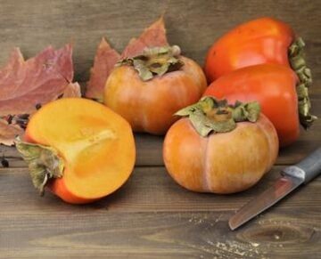 Persimmon Fruits On Wooden Background