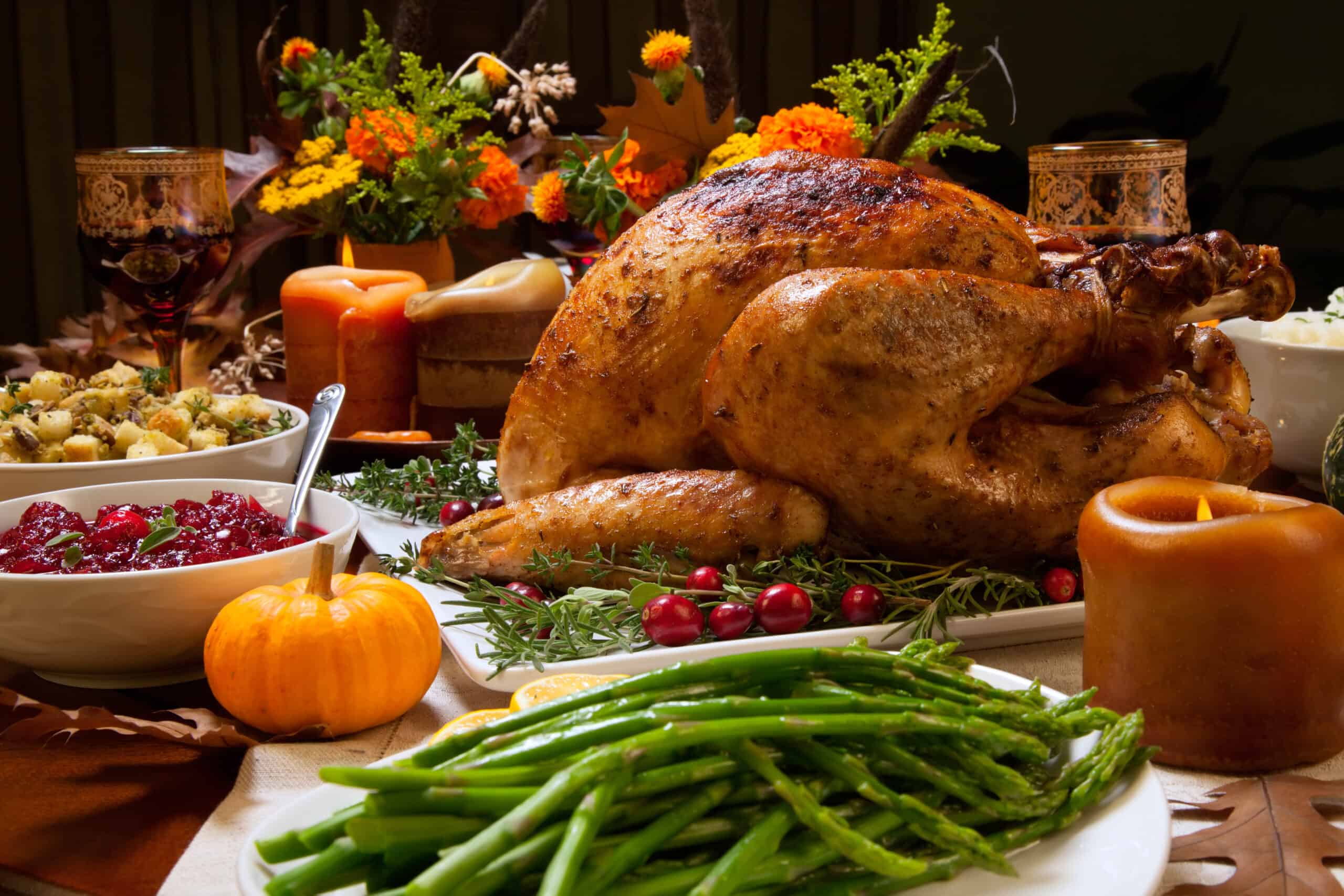 Roast Turkey with Herbal Rub on a holiday table with fresh green beans and mini pumpkin decor