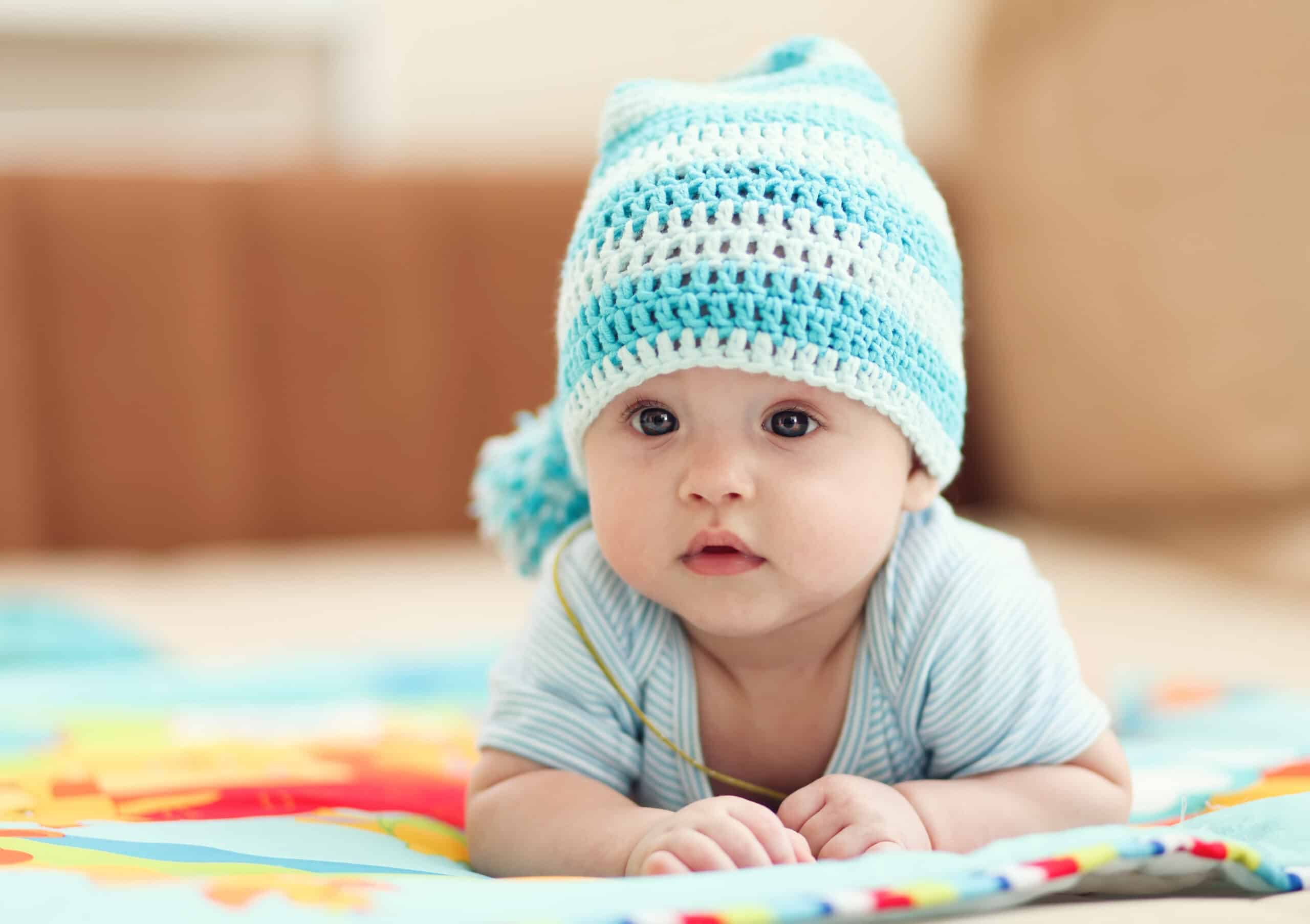 little child lying on a children's rug in the white-blue cap. Small Depth of Field (DOF)
