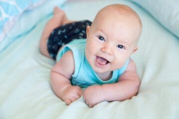 Happy baby boy lying on his belly, enjoying tummy time