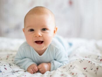 cute baby boy on his belly smiling