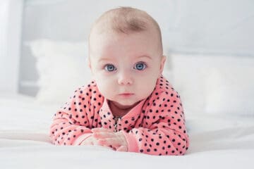 Cute baby in pink outfit with serious face
