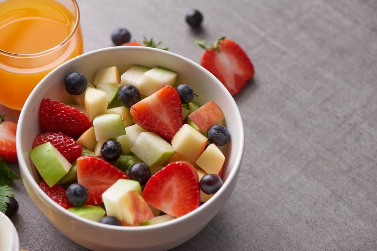 Bowl of healthy fresh fruit salad. fresh fruit and vegetable salad, healthy breakfast. bowl of oat granola with yogurt.