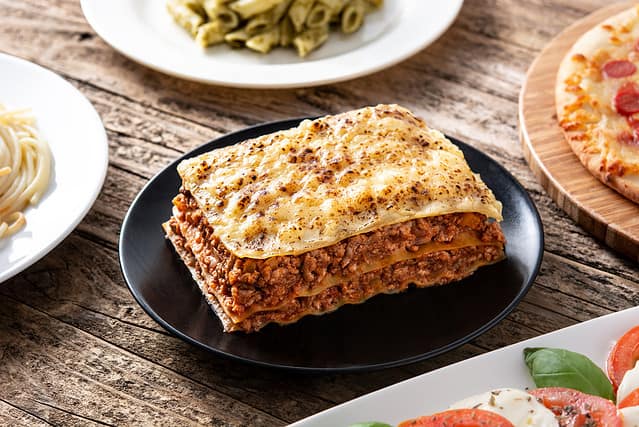 Assortment of Italian pasta dishes on wooden table