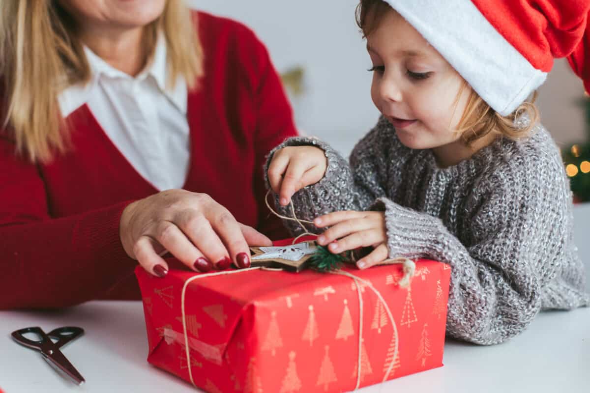 kid wrapping present with mom