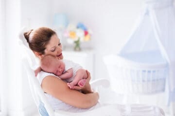 Young mother holding her newborn child. Mom is nursing the baby.