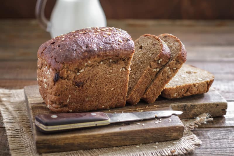 Loaf of brown bread on cutting board, ready to enjoy. MomsWhoThink.com is your source for dinner ideas and holiday recipes.