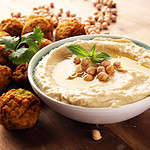 Traditional homemade hummus, falafel, and chickpea in the background. Jewish Cuisine.