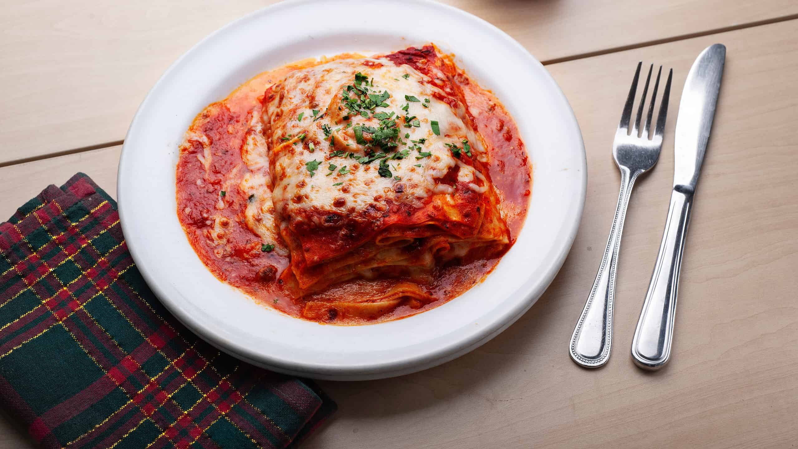 Lasagna Bolognese. Layers of flat lasagna noodles baked with alternating layers of slow-cooked Bolognese sauce, bechamel, and Parmesan cheese.