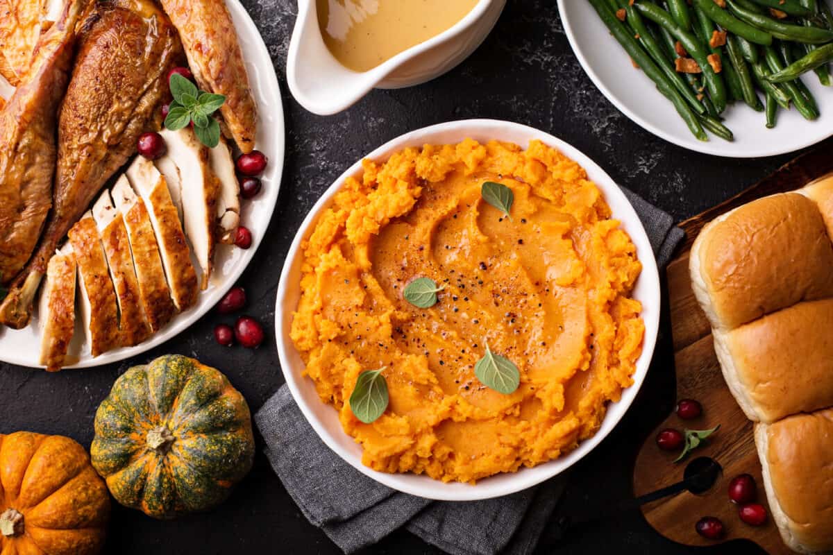 Sweet Potato Casserole in a serving dish along other food dishes