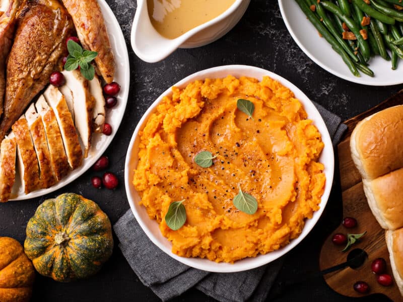 Sweet Potato Casserole in a serving dish along other food dishes