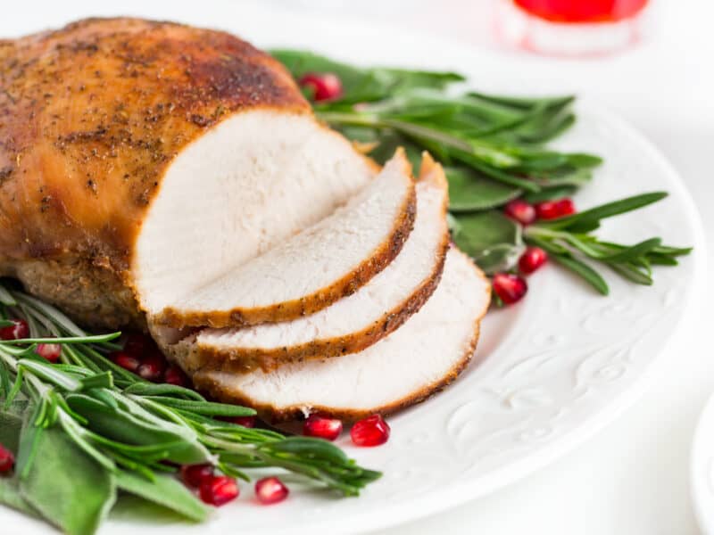 Herb Roasted Turkey Breast sliced with green and cranberries