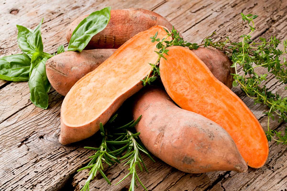 Yams and Apples - Raw yams piled on a wooden table